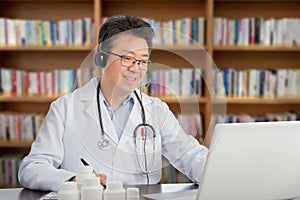 An Asian doctor who is remotely consulting with a patient. Telehealth concept