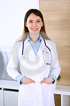 Asian doctor woman happy and cheerful while standing in hospital office. Medicine and health care concept