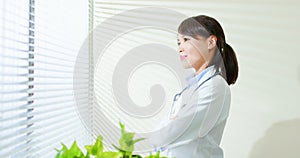 Asian doctor woman look outside