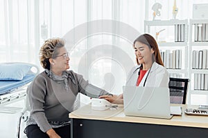 Asian doctor working in the office and discussing to the patient about her symptoms