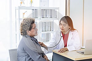 Asian doctor working in the office and discussing to the patient about her symptoms