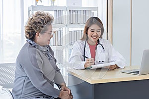 Asian doctor working in the office and discussing to the patient about her symptoms