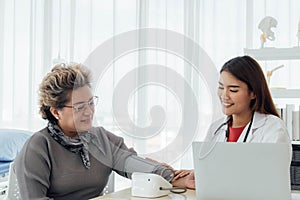 Asian doctor working in the office and discussing to the patient about her symptoms