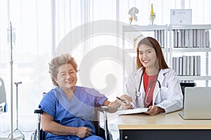 Asian doctor working in the office and discussing to the patient about her symptoms