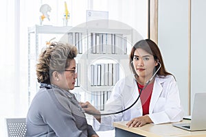 Asian doctor working in the office and discussing to the patient about her symptoms