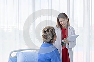 Asian doctor working in the office and discussing to the patient about her symptoms