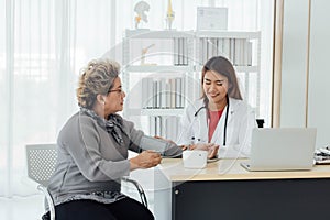 Asian doctor working in the office and discussing to the patient about her symptoms