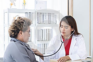 Asian doctor working in the office and discussing to the patient about her symptoms