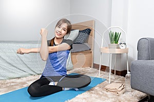 Asian doing home fitness and yoga on a fitness mat doing exercise at modern home in living room, sporty girl health care workout