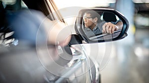 Asian driver man leaning arm out of car window