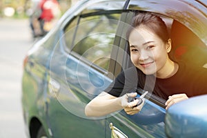 Asian driver woman smiling with new car keys