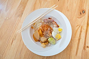 Asian dry noodle with garnish on the wooden background