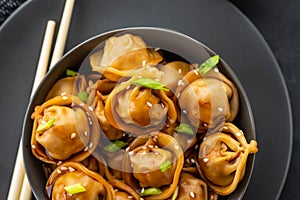 Asian dumplings in bowl, chopsticks, plates. Asian table setting. Chinese dumplings for dinner. Selective focus. Asian