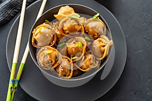 Asian dumplings in bowl, chopsticks, plates. Asian table setting. Chinese dumplings for dinner. Selective focus. Asian style