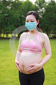 Asian Eastern Chinese happy pregnant woman wear a mask to protect baby from novel coronavirus virus health love concept