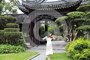 Asian Eastern Chinese young artist player woman carry play violin perform music park garden outdoor nature ancient building