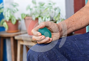 Asian elder man gripping hand exercise elastic ball