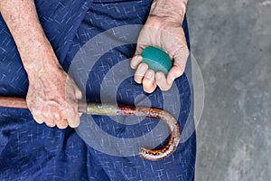 Asian elder man gripping hand exercise elastic ball