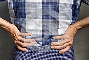 Asian elder man suffering from back and loin pain. It can be caused by renal stone