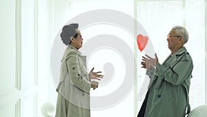 Asian elder senior couple thrown red heart balloon give and receive love marriage life secret