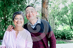 Asian elderly couple standing in the park, they are smile and happy together
