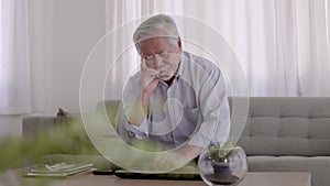 Asian Elderly have a headache. On the sofa in the living room