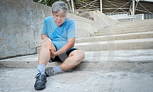 Asian elderly man, is currently having a knee injury during her exercise by running in the stairs