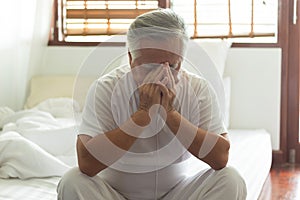 Asian Elderly man have pain head in bedroom