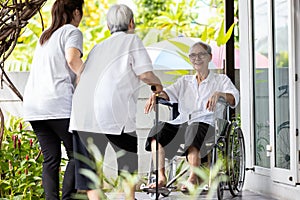 Asian elderly mother and her daughter to visit meet an old friend,friendly senior woman sit in wheelchair welcoming childhood