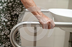 Asian elderly old lady woman patient use toilet bathroom handle security in nursing hospital, healthy strong medical concept