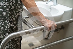 Asian elderly old lady woman patient use toilet bathroom handle security in nursing hospital, healthy strong medical concept