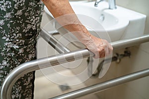 Asian elderly old lady woman patient use toilet bathroom handle security in nursing hospital, healthy strong medical concept