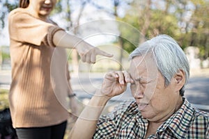 Asian elderly people crying while young caregiver scolding,angry annoyed woman getting mad pointing finger to senior woman, girl