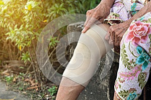 Asian Elderly people or older woman wearing the knee support or athlete knee strap to decrease knee pain,healthy concept