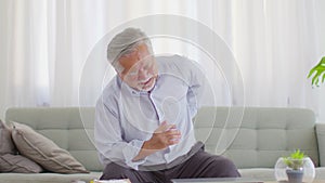 Asian Elderly senior man back pain and illness on sofa at home,Elderly Care Concept