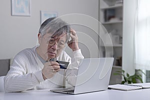 Asian elderly senior retired man, stressed worried sad frustrated male having problem with paying, buying online