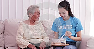 Asian elderly woman being fed by a nurse by volunteer with happy emotion.