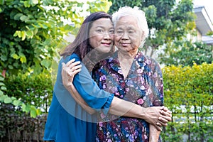 Asian elderly woman with caregiver walking with happy in nature park