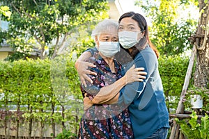 Asian elderly woman with caregiver walking with happy in nature park