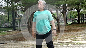 Asian elderly woman doing exercise, starting with warm-up arms and legs