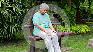 Asian elderly woman exercising in the park She did stretching exercises to relieve knee pain.