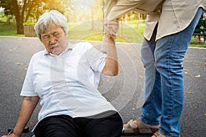 Asian elderly woman fell to the floor after tripped over something, female caregiver or daughter help care to her in nursing home,