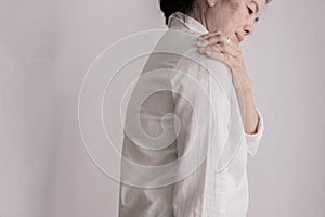 Asian elderly woman having shoulder pain on  white background. side view