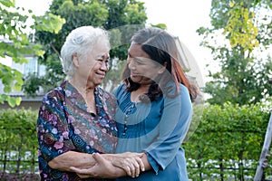 Asian elderly woman hug with her daughter with love, care, help, encourage and empathy at park, healthy strong medical concept