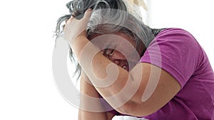 Asian elderly woman lying in bed have a headache Stressed