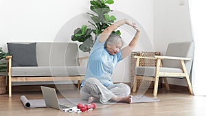 Asian elderly woman sitting at home exercising