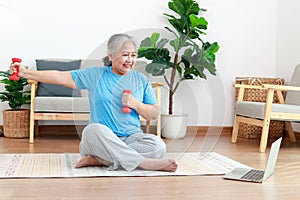 Asian elderly woman sitting at home exercising