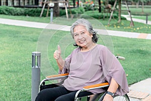 Asian elderly woman sitting in a wheelchair, she smile and was happy