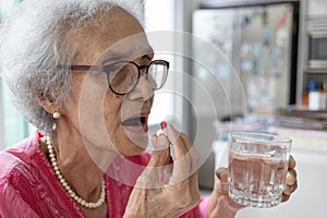 Asian elderly woman are taking and eating medicines and vitamins