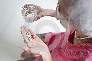 Asian elderly woman are taking and eating medicines and vitamins